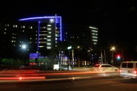 A photo of Phoenix Children's Hospital illuminated at night as cars drive by.