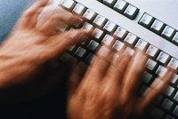 A photo of hands typing on a keyboard.