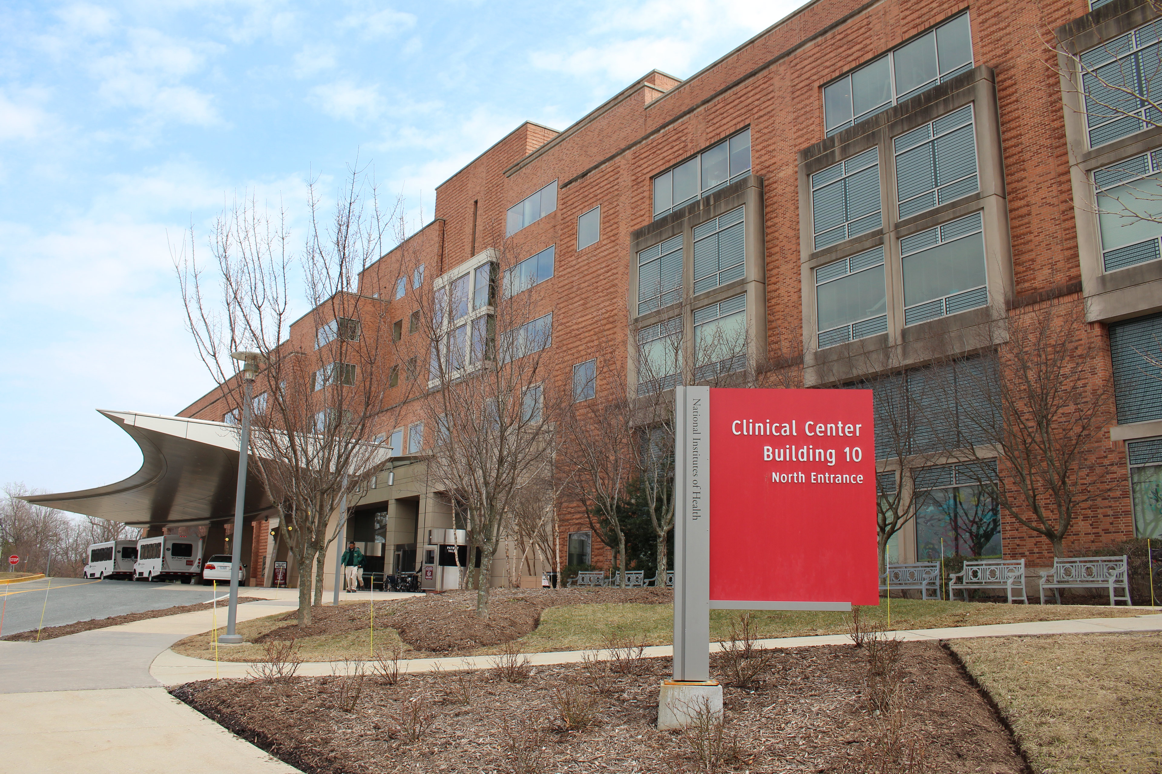A photo of the exterior of the NIH Clinical Center. A red sign out front identifies it as Building 10.