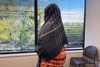 A photo of a woman in a headscarf facing away from the camera.