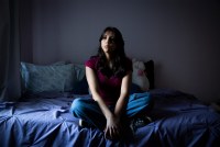 A photo of a teenage girl posing for a portrait in her bedroom.
